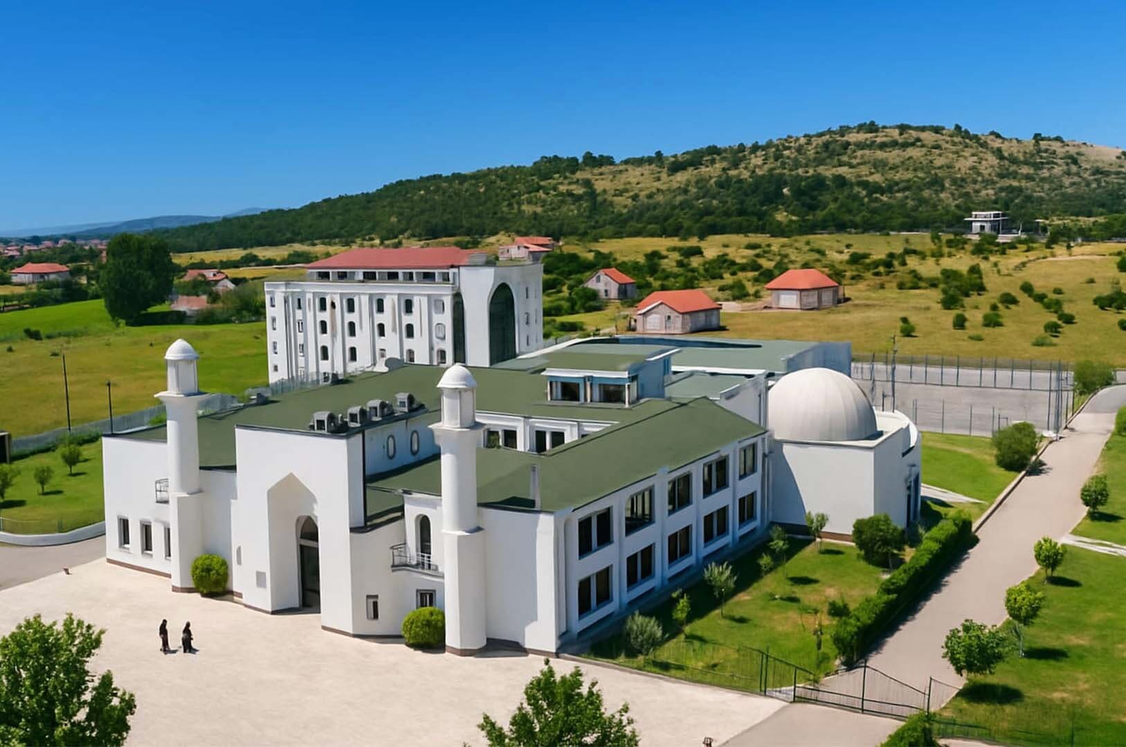 Zgrada Medrese „Mehmed Fatih“ u Tuzima sa minaretima i kupolom, u podnožju brda
